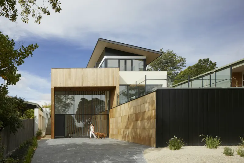 Casa contemporánea con fachada de madera y grandes ventanales
