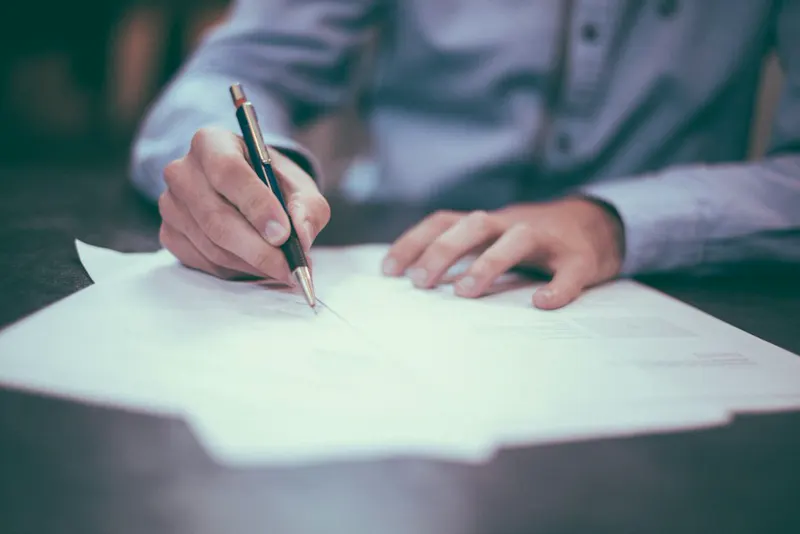 Asesor revisando y firmando los documentos de una propiedad